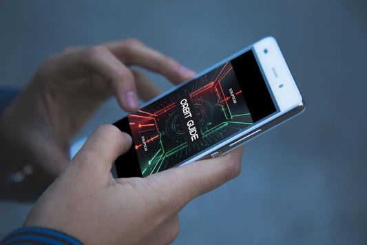 Person holding a smartphone with a 'Orbit Guide' course interface on the screen.